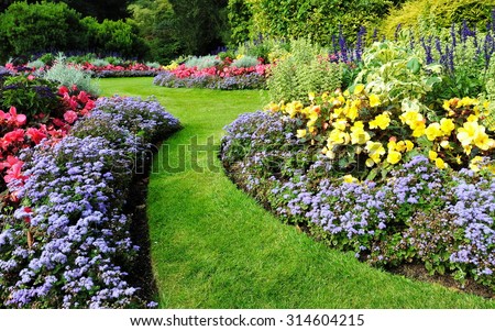Scenic View of Colourful Flowerbeds and a Winding Grass Lawn Pathway in an Attractive English Formal Garden