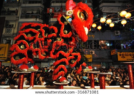 YANGON - FEB 11: A dance troupe perfom a tradition lion dance on a downtown street during celebrations ushering in the Chinese new year of the snake on Feb 11, 2013 in Yangon, Myanmar.
