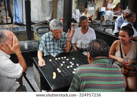 SINGAPORE - MAY 10: Men play checkers on a street in the city state\'s Chinatown district on May 10, 2013 in Singapore. Ethnic Chinese began settling in Chinatown circa 1820.