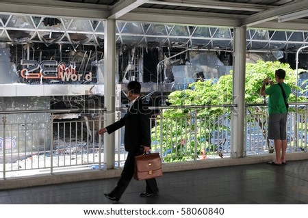 BANGKOK - MAY 25: Passersby survey the fire damaged exterior of Zen Central World shopping mall in the aftermath of the anti government \'Red Shirt\' protest May 25, 2010 in Bangkok, Thailand.