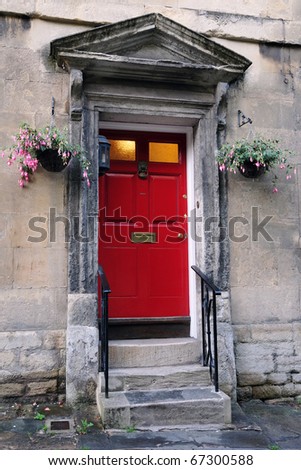 View of a Red Front Door and Hanging Flower Baskets of a Traditional English Town House in London