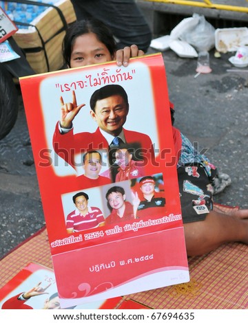 BANGKOK - DECEMBER 19: A Red Shirt at a protest at Rachaprasong displays an image of Thaksin Shinawatra, former PM of Thailand who was ousted in a 2006 coup on December 19, 2010 in Bangkok, Thailand.