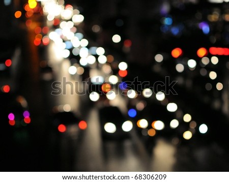 Blurred Defocused Lights of Heavy Traffic on a Wet Rainy City Road at Night -  Commuting at Rush Hour Concept