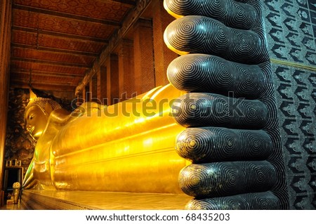 The Golden Reclining Buddha Statue Built Circa 1800 in Wat Pho Bangkok with Focus on the Foreground - Wat Pho is One of Thailand\'s most Sacred Regilious Sites and also a Popular Tourist Attraction.