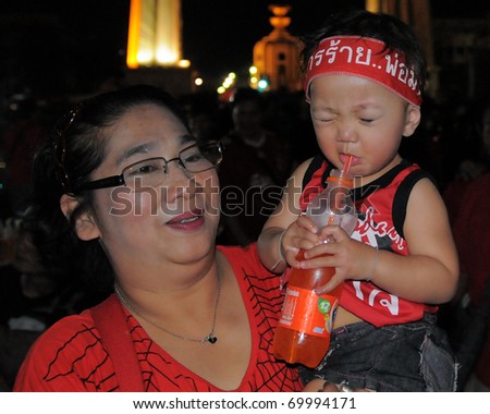 BANGKOK - JAN 23: An anti-government red-shirt protester with her infant son at a rally at Democracy Monument on Jan 23, 2011 in Bangkok, Thailand. The red-shirts are calling for political change.