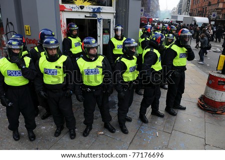 LONDON - MARCH 26: Riot police stand guard outside a branch of HSBC after the bank is vandalized by a breakaway group of protesters during a large anti-cuts rally on March 26, 2011 in London, UK.