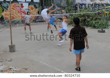 BANGKOK - JAN 20: Takraw players compete in a street match on derelict land Jan 20, 2011 in Bangkok, Thailand. Takraw also known as Kick Volleyball is one of the national sports of Thailand.
