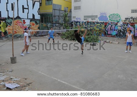 BANGKOK - JAN 20: Takraw players compete in a street match on derelict land Jan 20, 2011 in Bangkok, Thailand. Takraw or Kick Volleyball is one of the national sports of Thailand.
