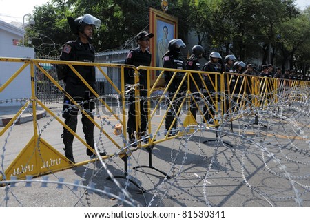 BANGKOK - FEB 11:  Riot police  guard a barricade outside Government House during a yellow-shirt protest on Jan 25, 2011 in Bangkok, Thailand. The Thai capital continues to see street protests.