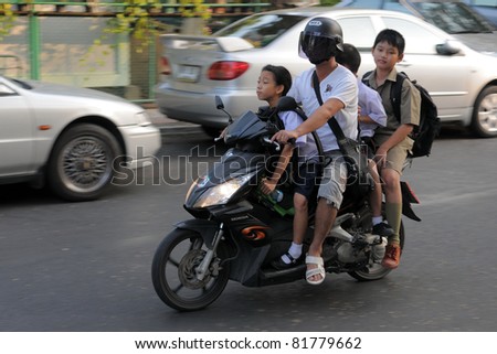 BANGKOK - JAN 20: Unidentified family school run on a motorbike Jan 20, 2011 in Bangkok, Thailand. The use of motorbikes as family transport is commonplace in Thailand.