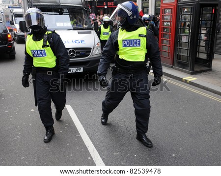 LONDON - MARCH 26: Police in riot gear advance through central London during a large anti-cuts rally on March 26, 2011 in London, UK.