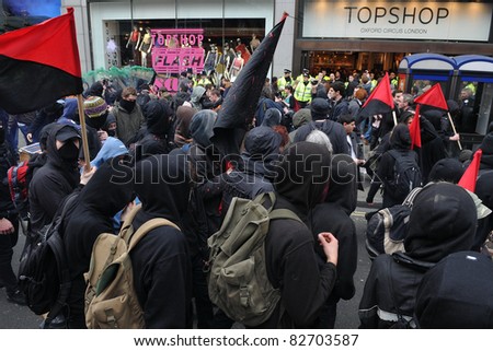 LONDON - MARCH 26: A breakaway group of anarchist protesters confront police outside a branch of Topshop during a large anti-cuts rally on March 26, 2011 in London, UK.