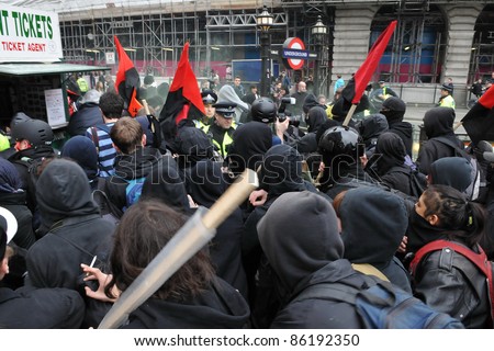 LONDON - MARCH 26: Anti-cuts protesters push through police lines on Picaddilly during a large anti-cuts rally on March 26, 2011 in London, UK.