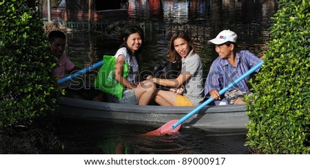 BANGKOK - NOV 4: Unidentified Bangkok residents navigates a flooded Bangkok street by boat Nov 4, 2011 in Bangkok, Thailand. Approximately one fifth of the Thai capital is submerged under floodwater.