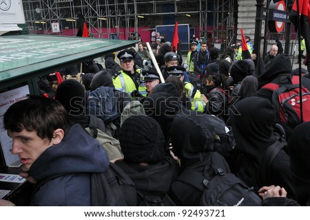 LONDON - MARCH 26: A breakaway group of protesters push through police lines on Picaddilly during a large austerity rally on March 26, 2011 in London, UK.