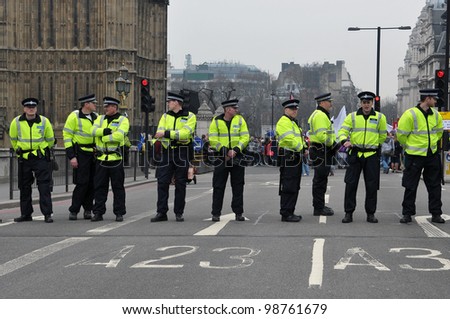 LONDON - MARCH 26: Police stand guard on Westminster Bridge during a large austerity rally on March 26, 2011 in London, UK. Police were on standby after violent clashes with anti-cuts protesters.