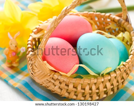 Easter eggs in basket with daffodil, selective focus