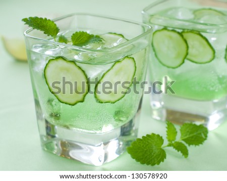 Cold fresh lemonade with cucumber and ice, selective focus