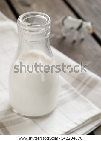 Milk in bottle with cow on background, healthy food. Selective focus
