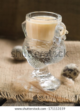 Milk or egg liquor with egg on background, selective focus