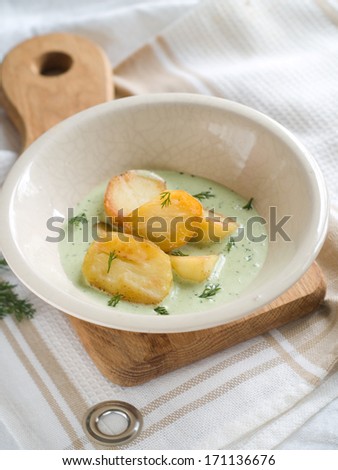 Baked potatoes with green sauce and dill, selective focus