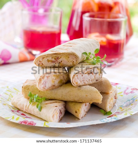 Tortilla wraps with chicken and vegetables on paper plate, selective focus