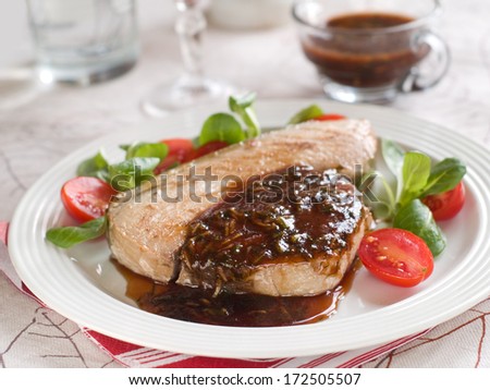 Grilled tuna steak with sauce and salad, selective focus
