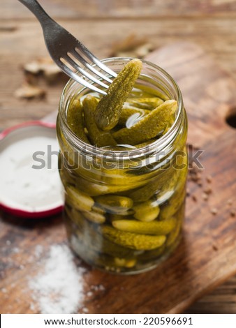 Preserved salted or marinated cucumber in glass jar, selective focus