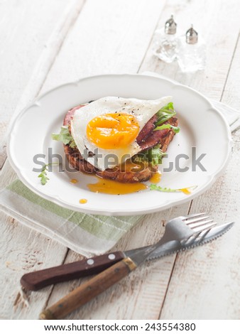 Fried egg and bacon on wholemeal bread, selective focus