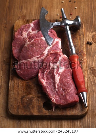 Raw fresh meat and meat cleaver on wooden board, selective focus