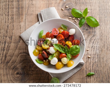Italian Caprese salad with cherry tomatoes and mini mozzarella, selective focus