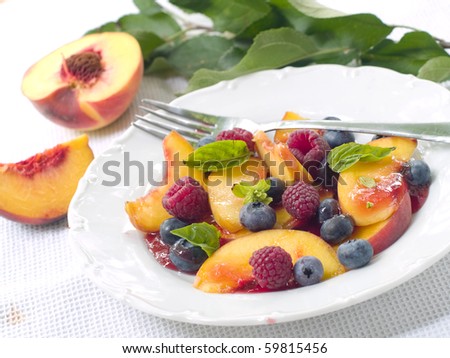 Mix of different fruits and berries salad on white plate