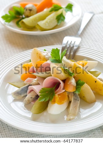 Salad with potato, ham, herring and cucumber for dinner