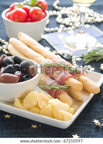 Sumptious platter served with olives, cheese and ham on bread sticks. Shallow DOF.