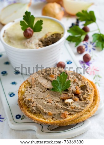 Bread with  liver pate in a white ramekin with antique silver knife.