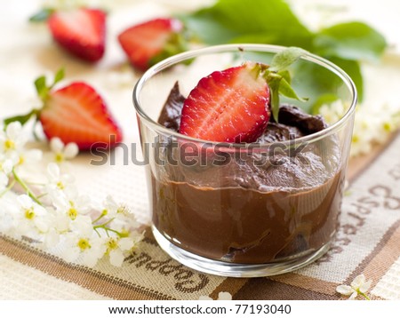 Chocolate Mousse dessert in a glass with strawberry. Shallow depth of field, focus on strawberry