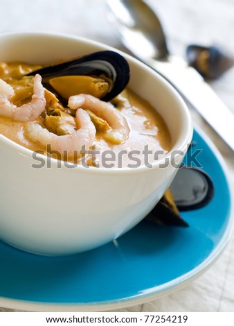 A bowl of seafood soup with shrimp and mussels. Shallow depth of field, selective focus