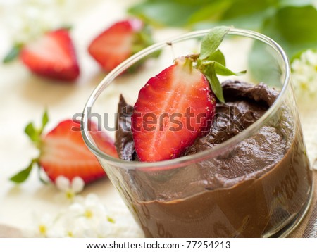 Chocolate Mousse dessert in a glass with strawberry. Shallow depth of field, focus on strawberry