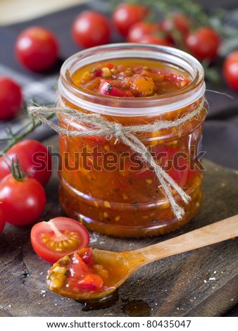 Tomato jam with pepper and garlic in wooden spoon. Selective focus, shallow doff