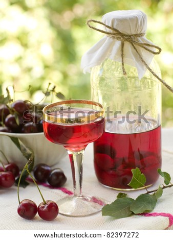 Cherry liquor in glass on natural background. Selective focus