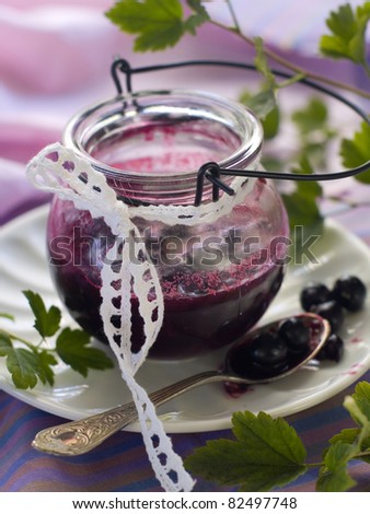 Black currant jam in glass jam-jar. Selective focus