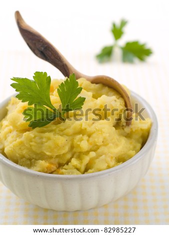 Mashed potato with wooden spoon, in serving bowl. Selective focus