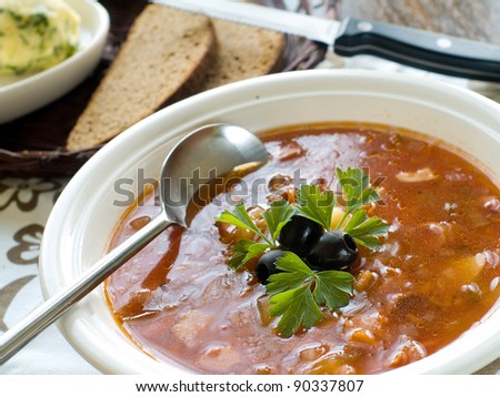 Bowl of vegetable soup with olive, selective focus