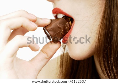 close up of woman's lips biting a bar of chocolate in a sexy way
