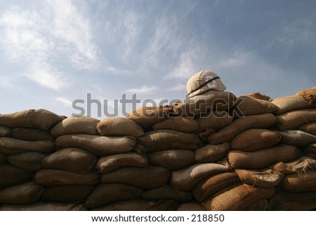 US Army Helmet on sandbag bunker. - stock photo