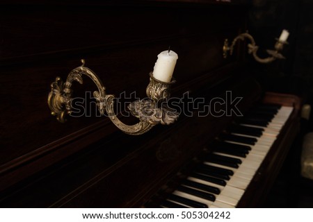 vintage chandelier on a brown piano in the gloom