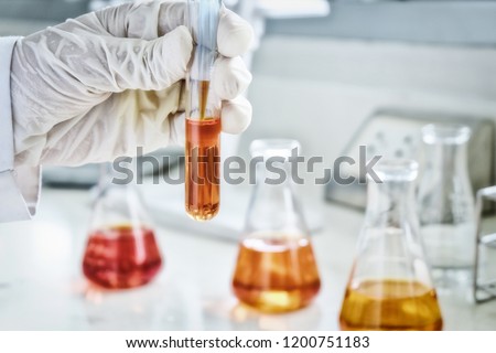 The scientist test the natural product extract, oil and biofuel solution, in the chemistry laboratory. sepia or retro tone