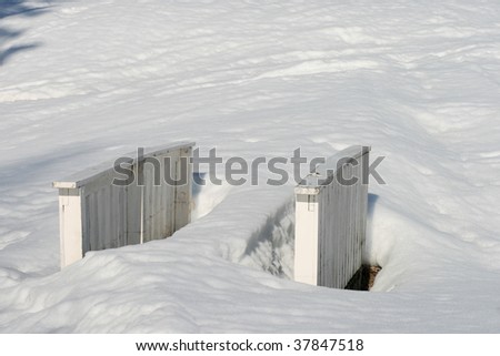 Small bridge at a golf course that has been buried in snow.