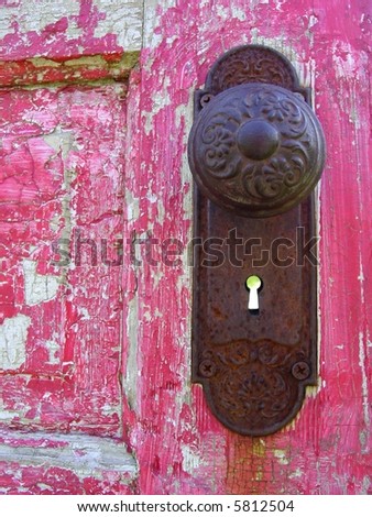 rusty old keyhole and door knob on red painted door