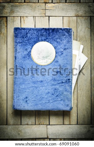Vintage photo album in a blue plush cover, on an old wooden table